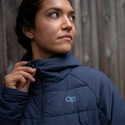 Woman wears the Shadow Insulated Hoodie in Naval Blue